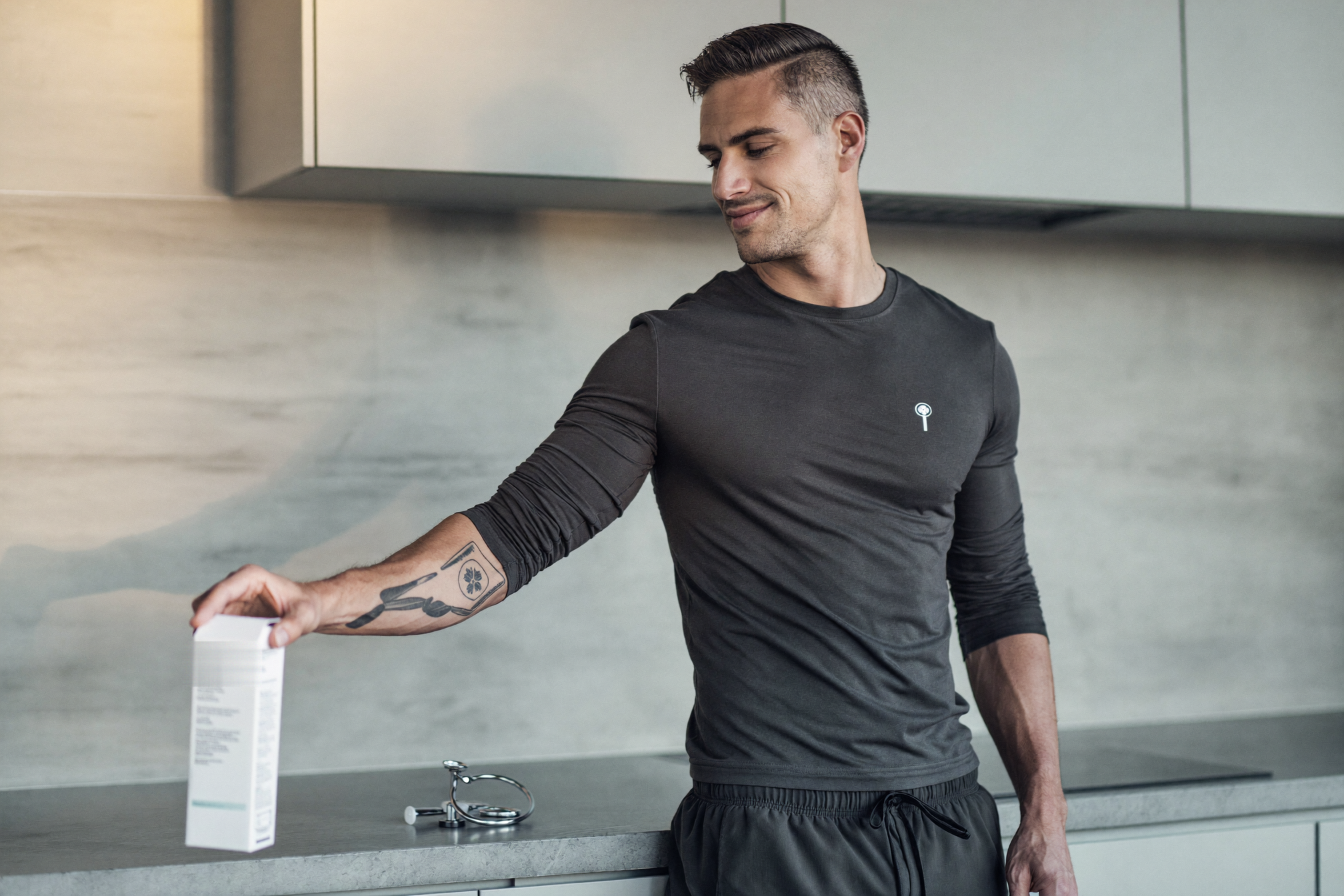 A man reaching for a carton of supplies at his kitchen bench