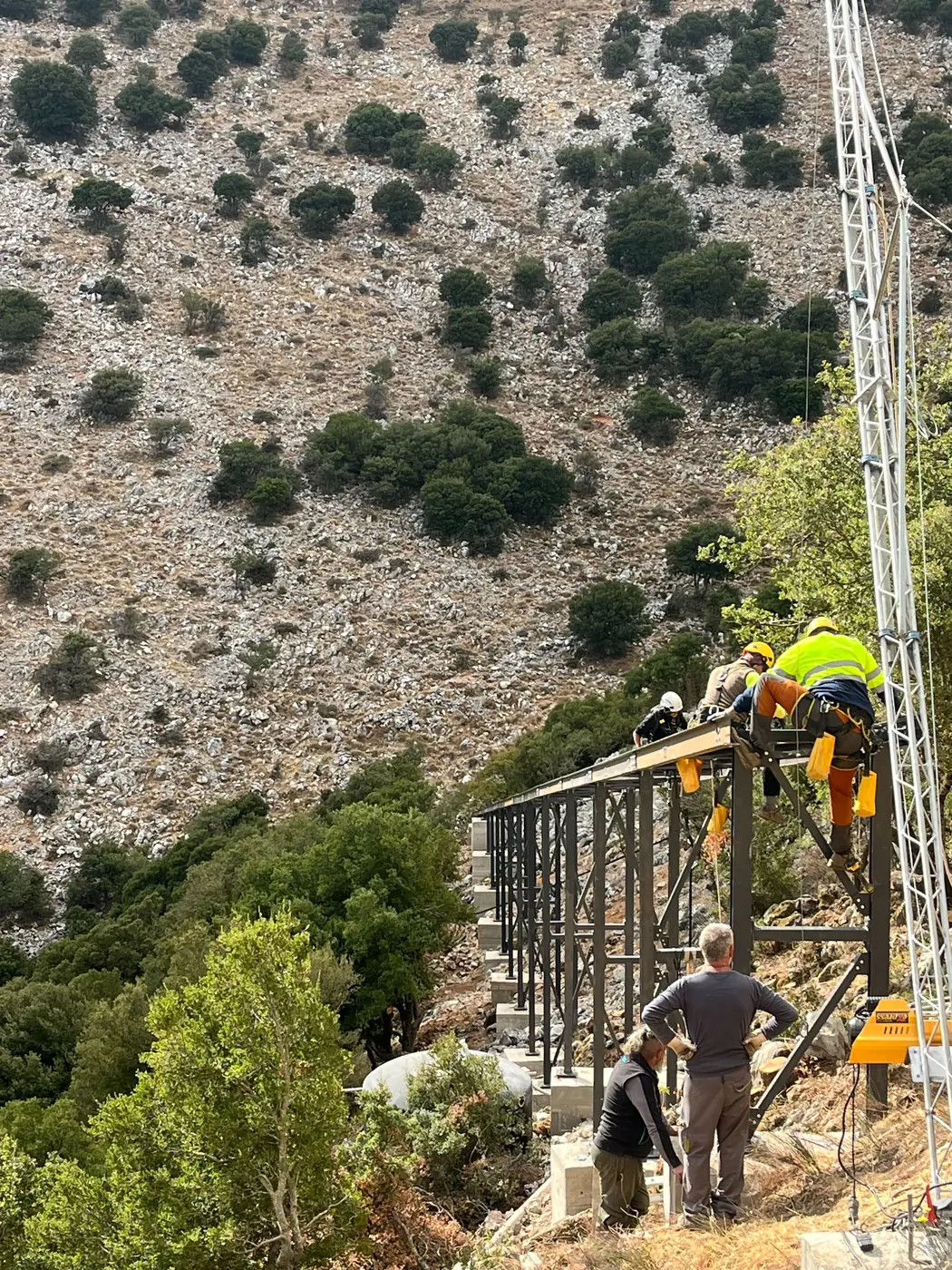 The steel access platform under construction on the scree slope below the cave