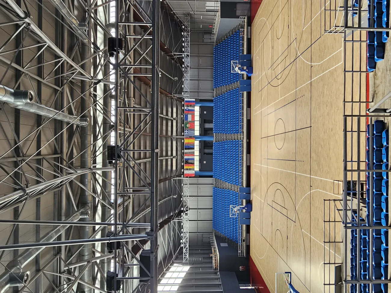 View down the steel roof trusses onto the court of the Karanastasis hall — built by Lydakis