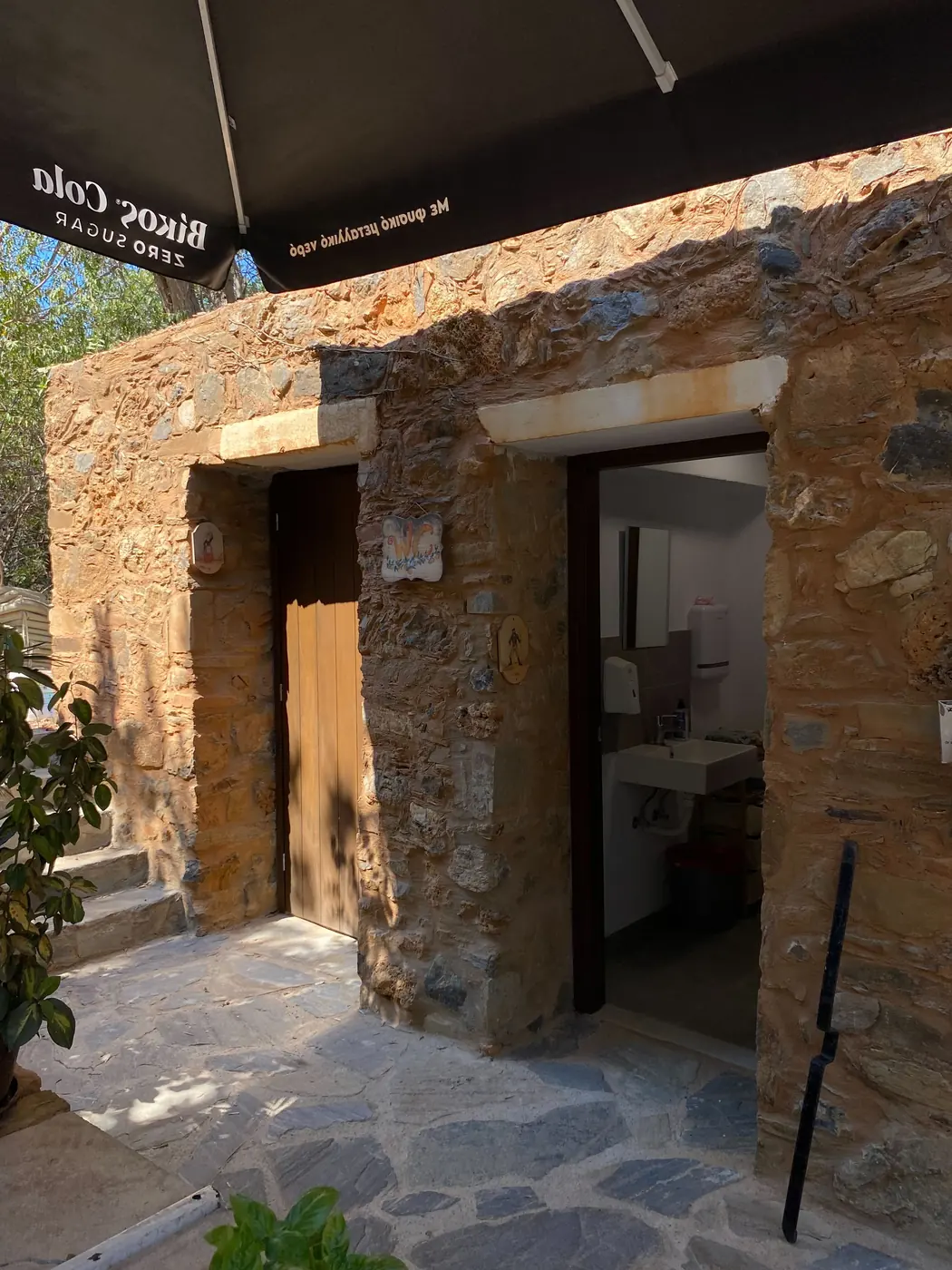 Stone building with the rebuilt WC entrances and new level paving outside