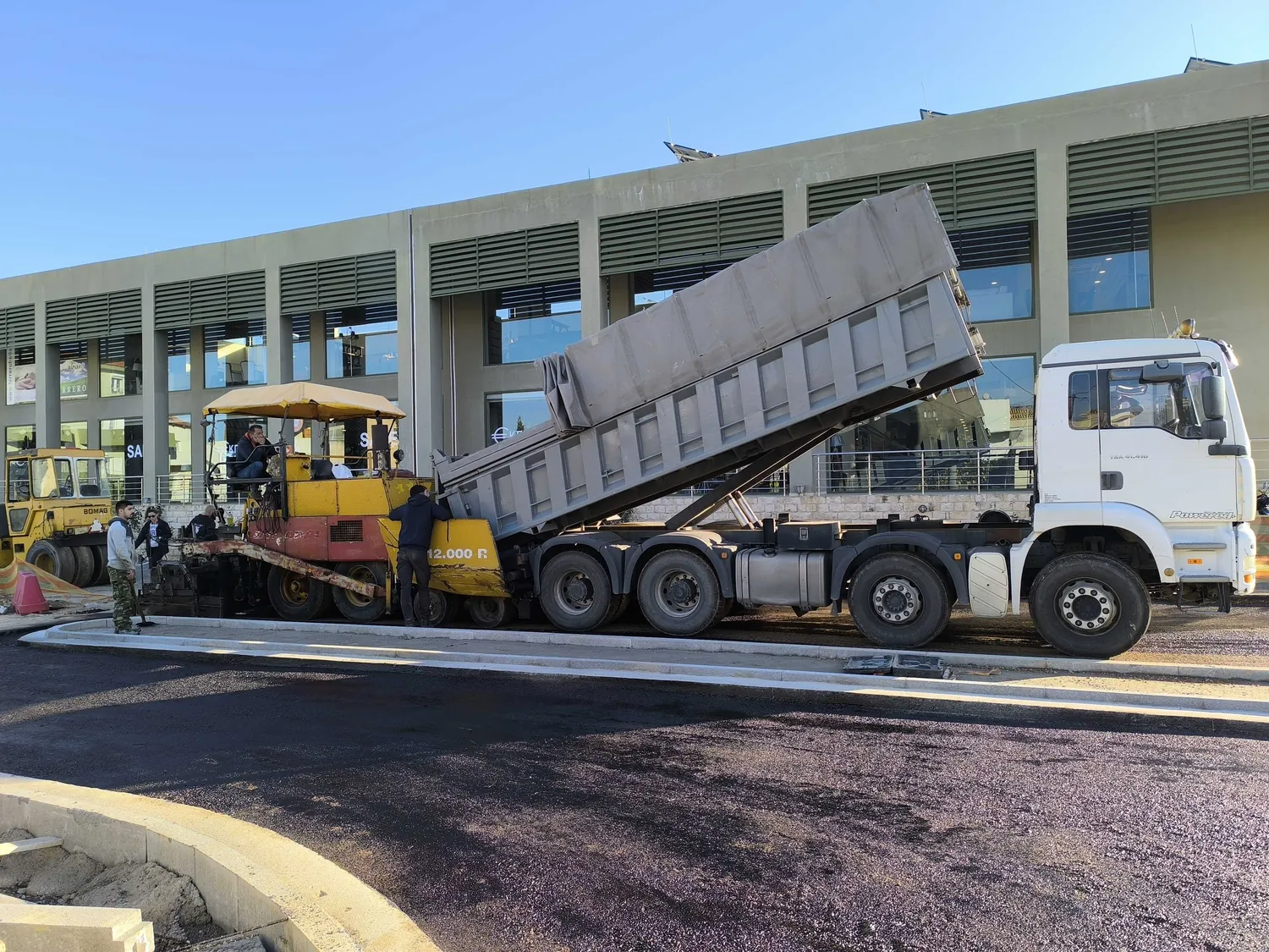 Asphalt being laid at the junction, a tipper feeding the paver