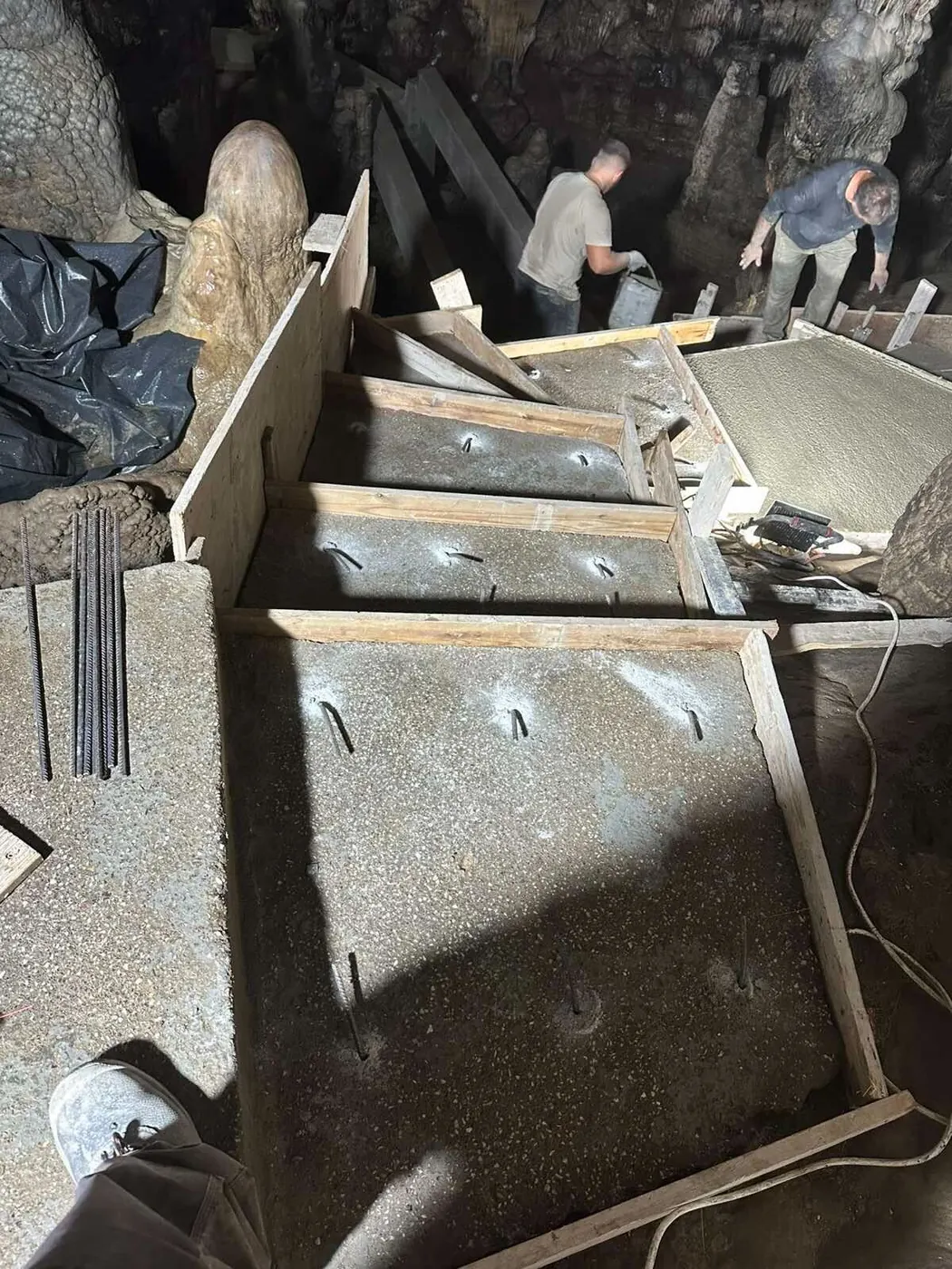 Freshly poured concrete steps in timber formwork inside the cave