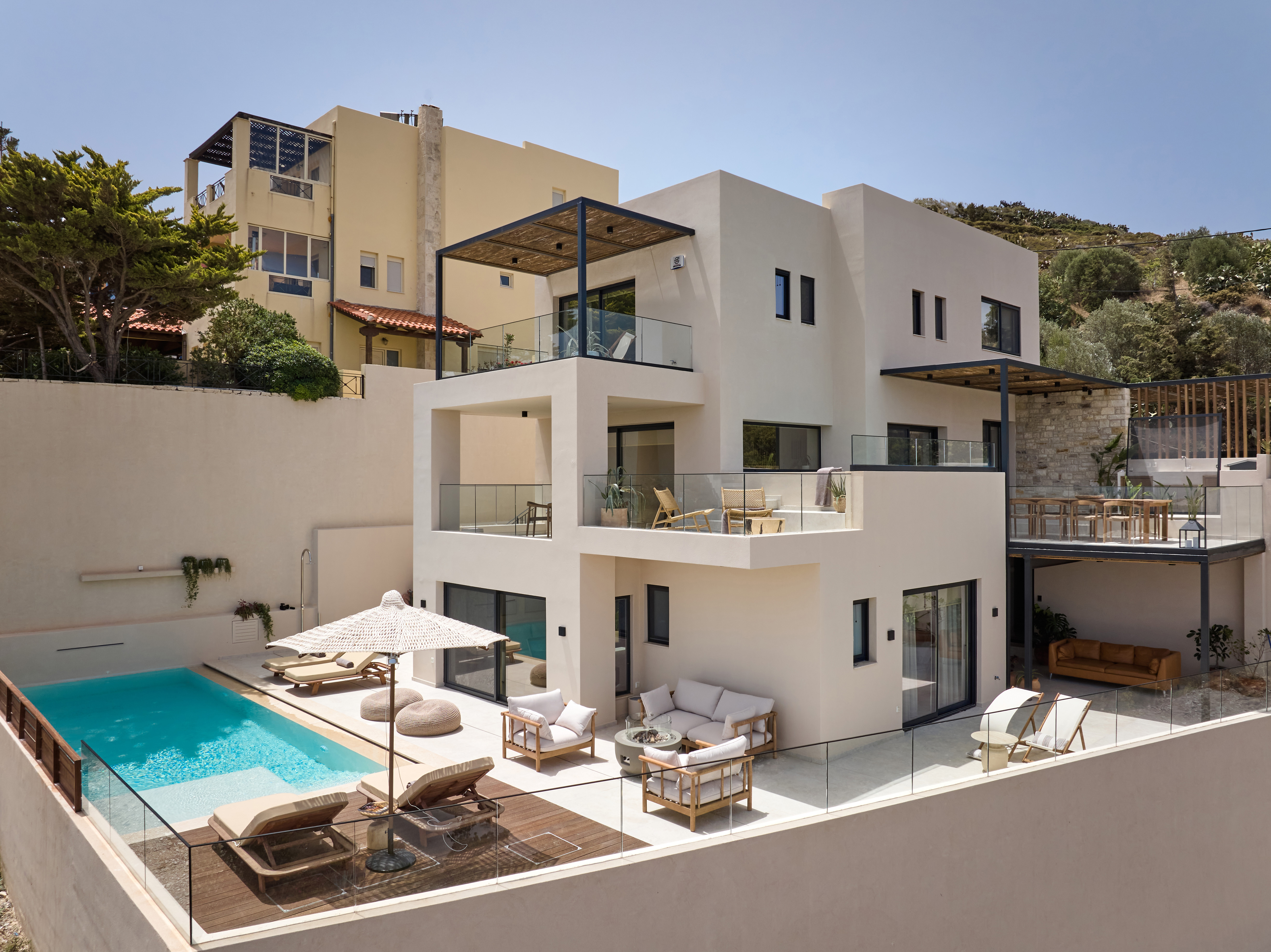 Pool terrace of The Nook Villa with sun loungers and umbrella