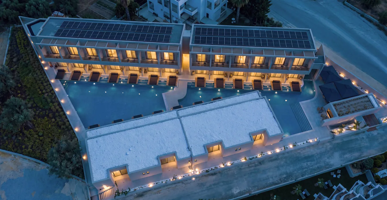 The new building at dusk from above, lights on