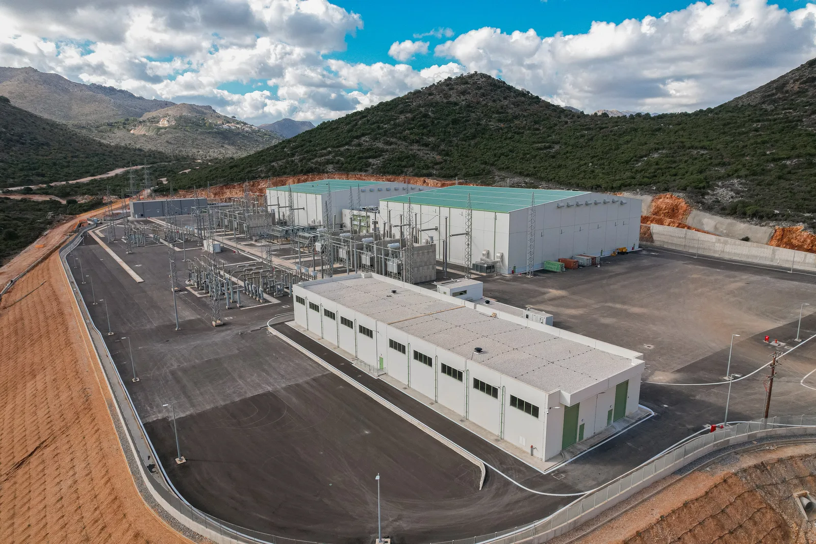 Aerial view of the completed Damasta HVDC converter station in its excavated mountain platform, north Crete