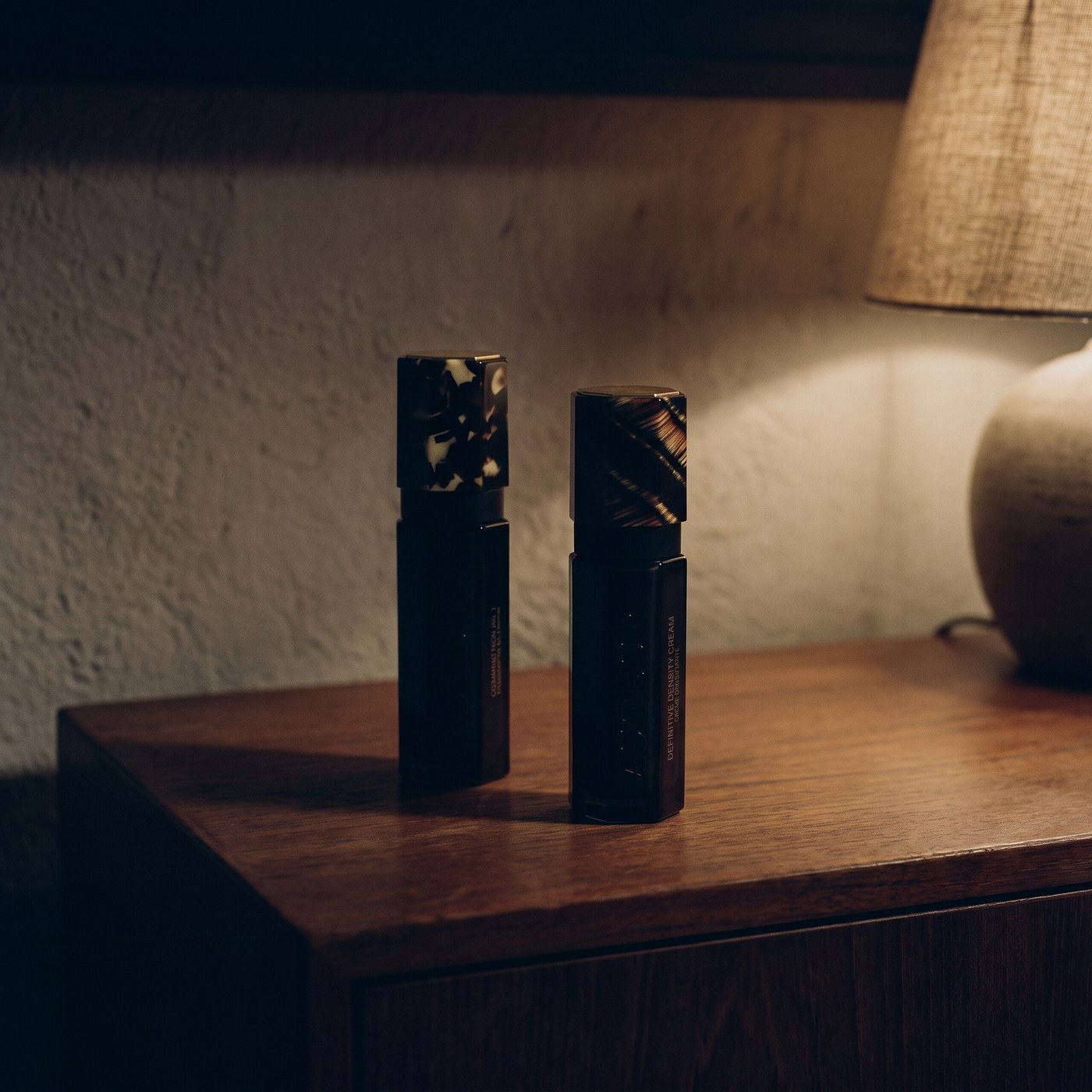 Seated at a teak console at night, a single lamp the only light