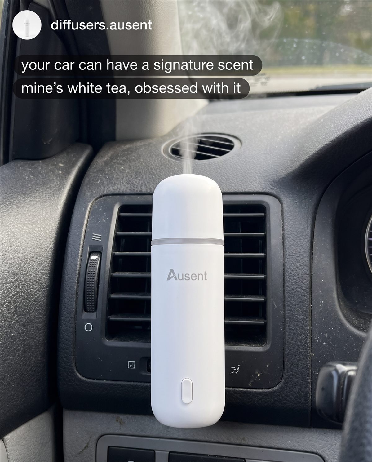 Ausent Aura Mini clipped to a car air vent, misting scent