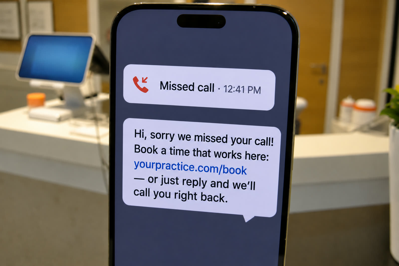 A phone at a reception counter showing an outgoing text message