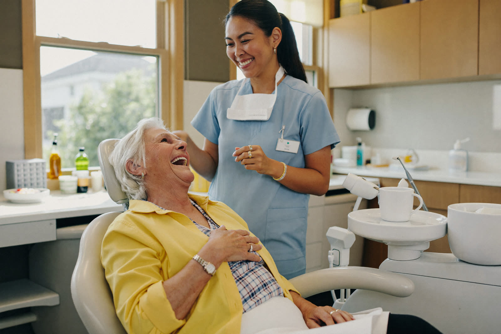 A happy senior patient laughing in the dental chair