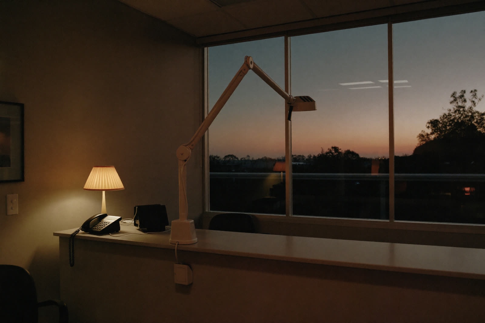 A dental reception desk at dusk with a softly glowing lamp
