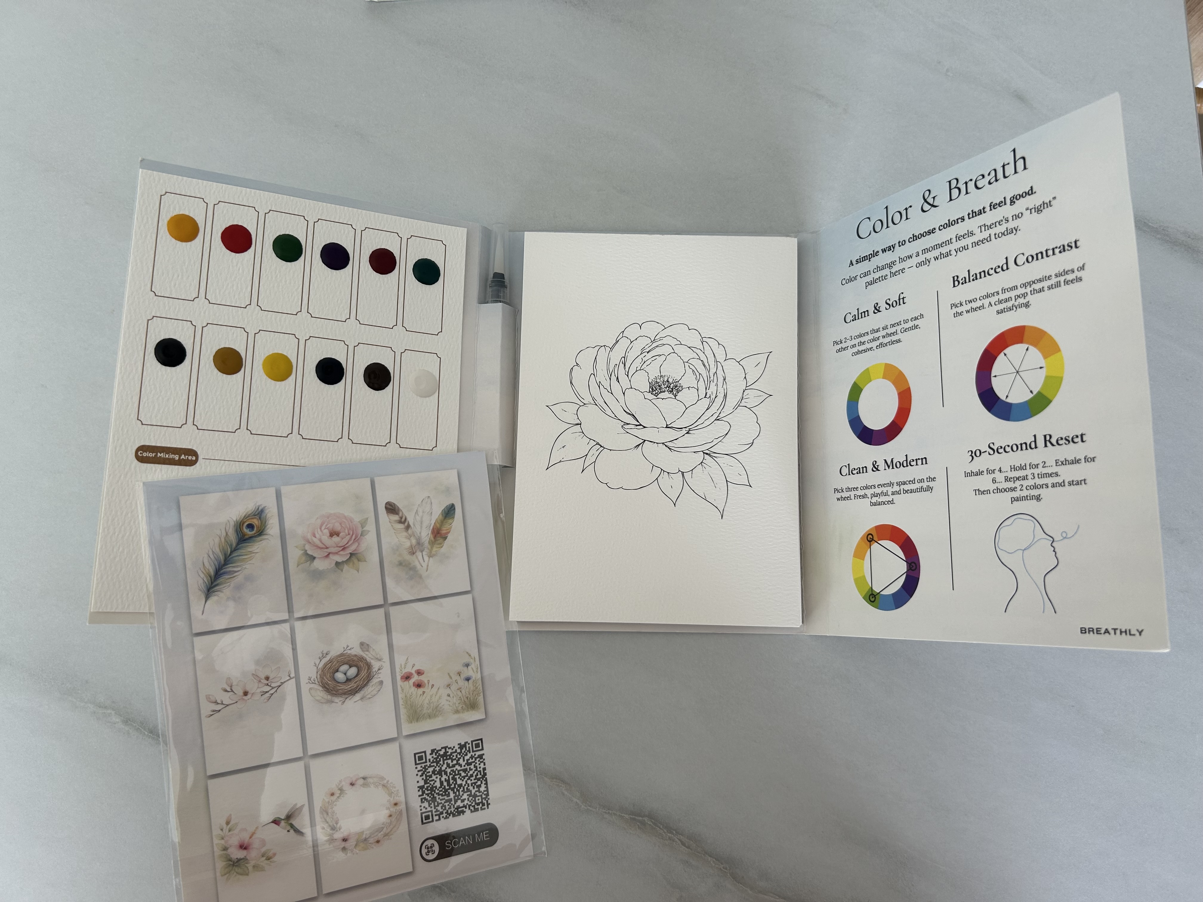 the guided pages and paint palette of a Breathly watercolor workbook