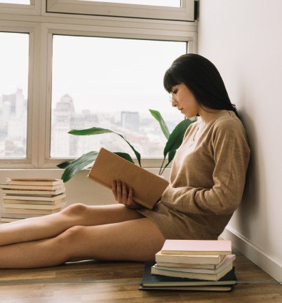 女士倚窗而坐閱讀