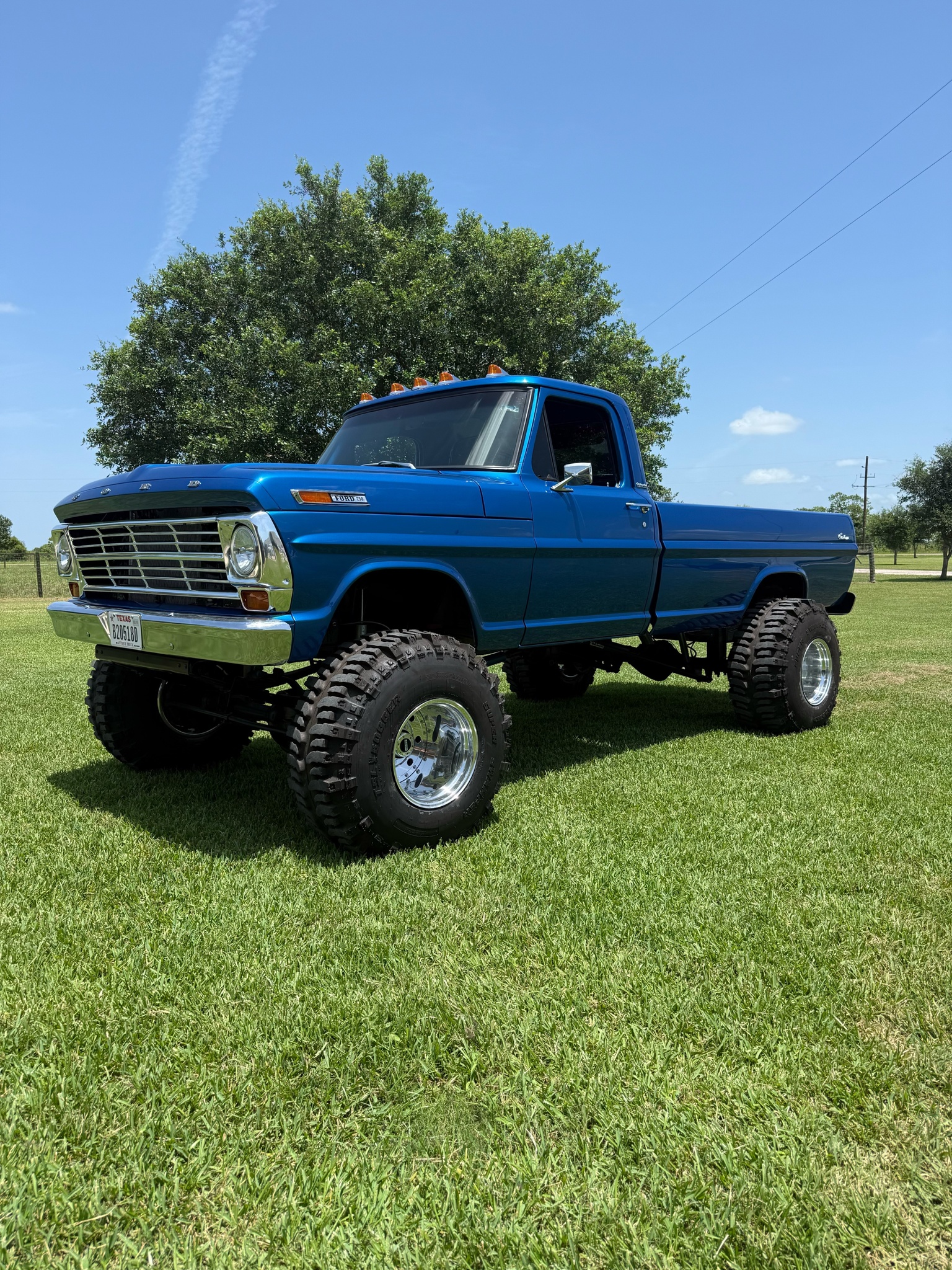 Lifted blue Ford F-250 with Shifted Forged Wheels on lawn