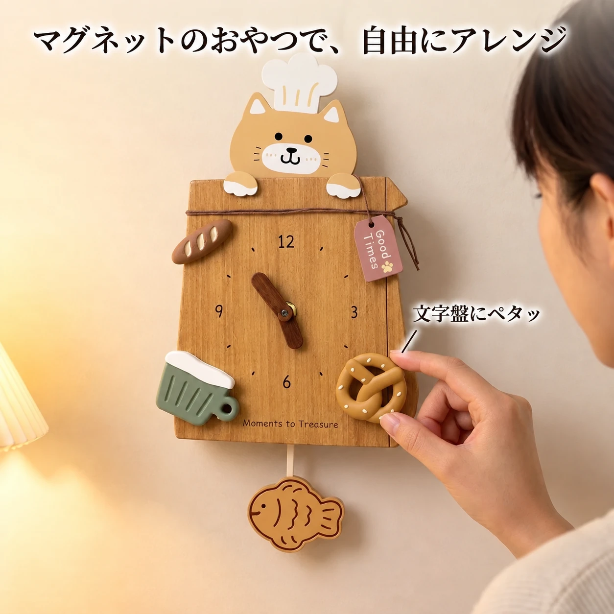 クリーム猫（コック帽）の文字盤に、マグネットの焼き菓子を貼り付けている手元