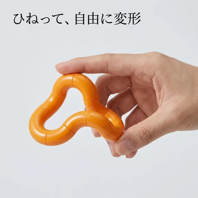 オレンジのねじねじフィジェットを手でひねって変形させる様子