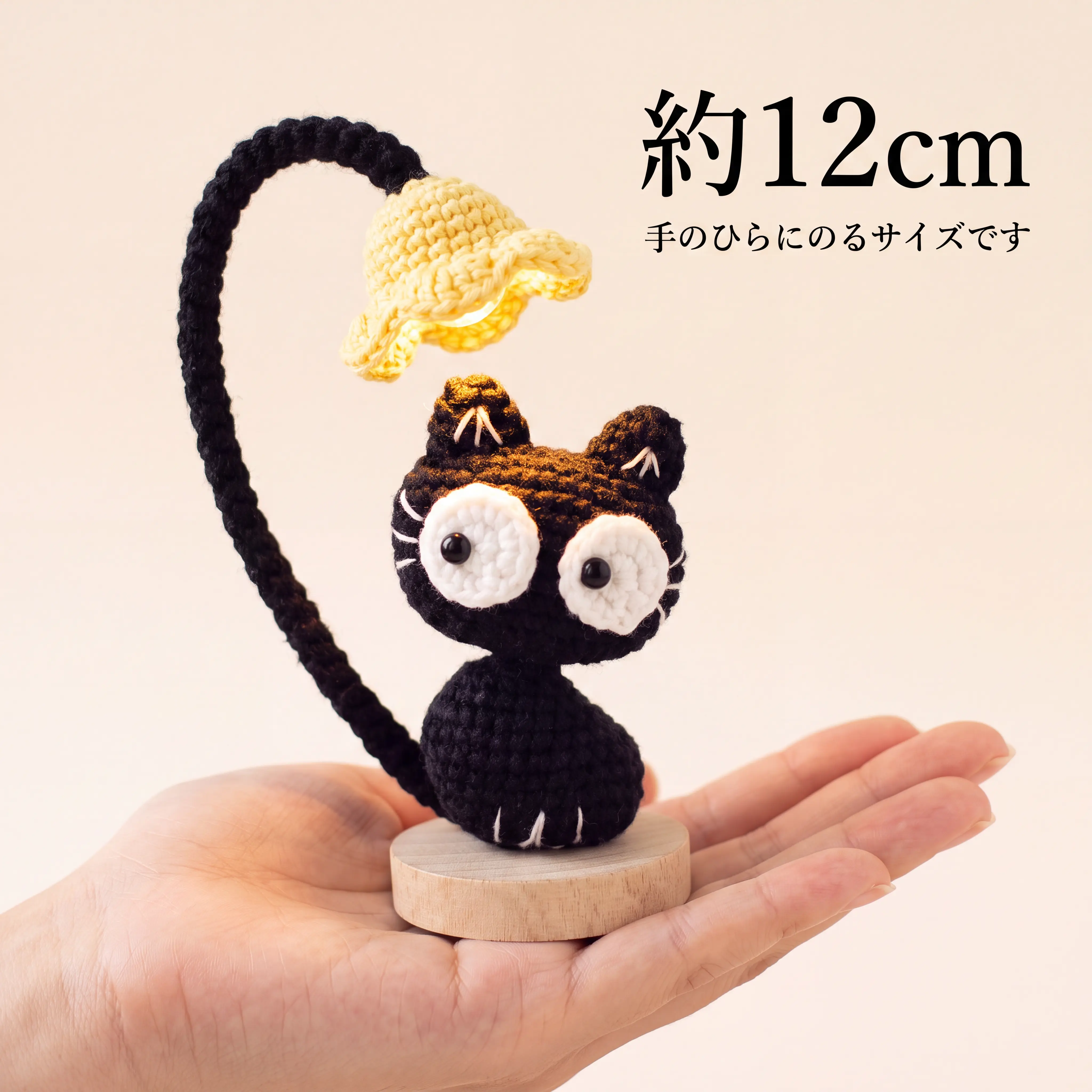 点灯した猫のランプを手のひらにのせたところ。全体で約12cm