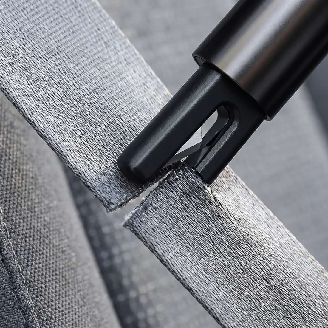 Drawing a seatbelt through the cutter