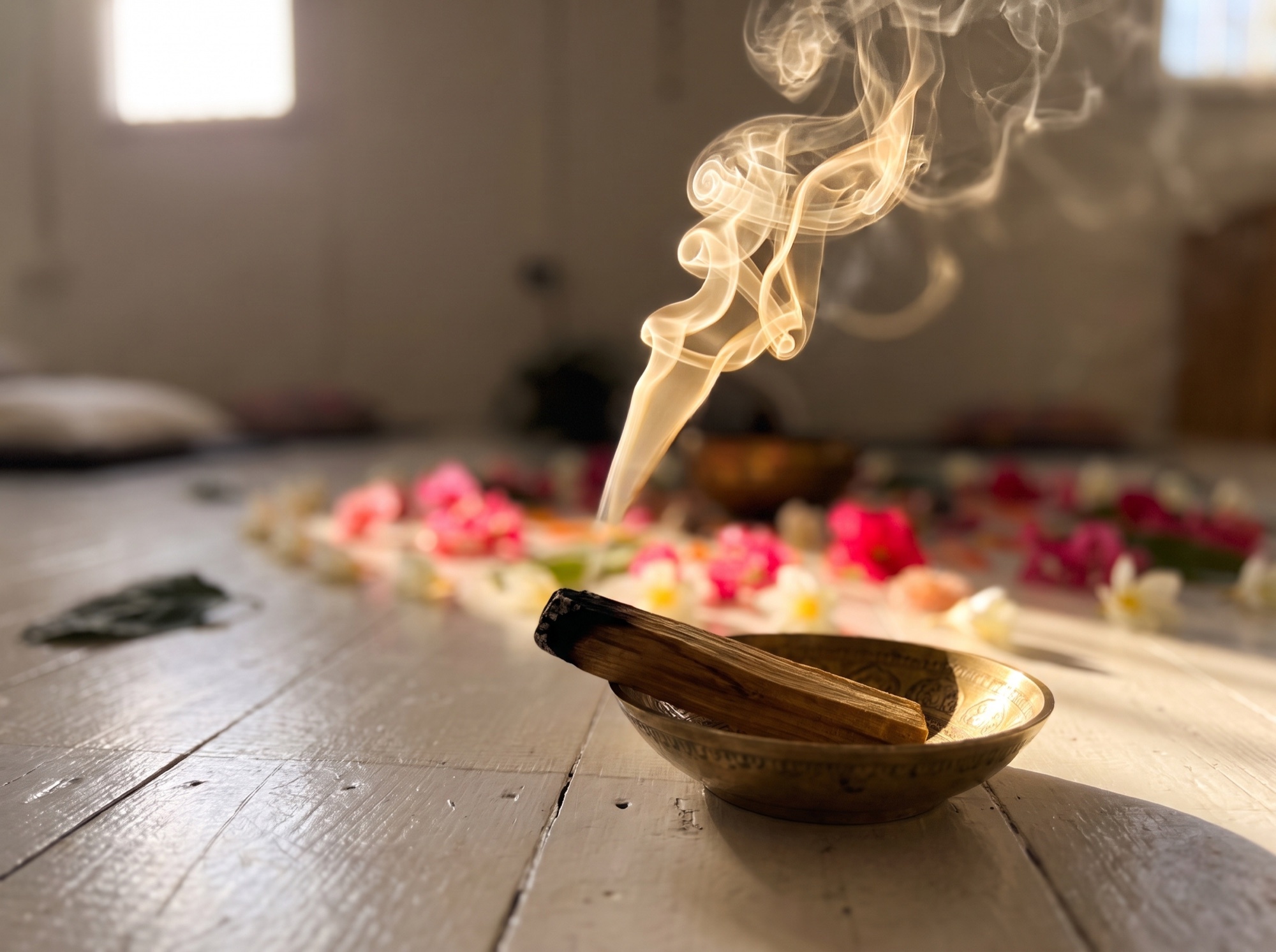 Palo santo smouldering in a brass dish beside a flower mandala