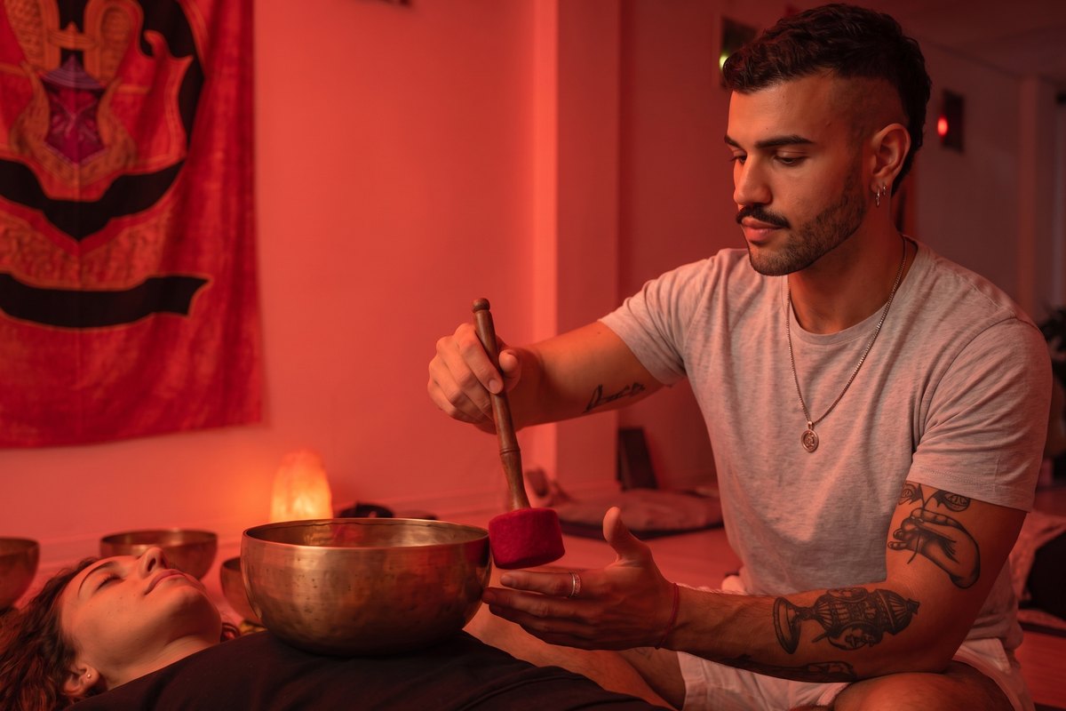 Singing bowl played over a guest in deep rest at Sound of Soma