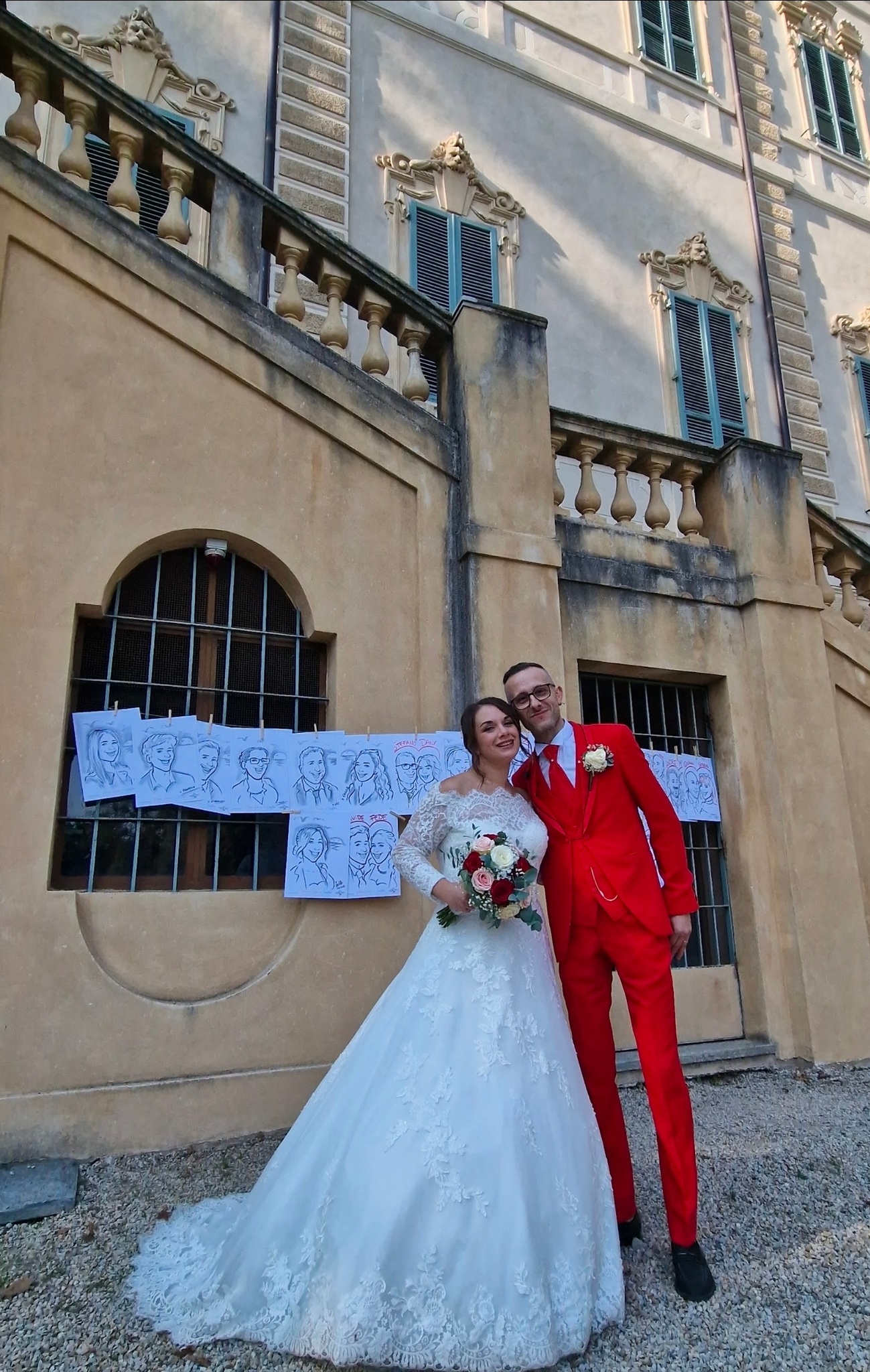 La sposa e lo sposo sorridenti davanti ai ritratti