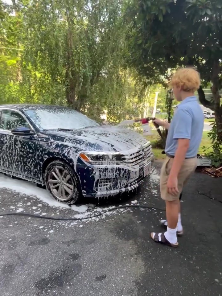 Michael spraying the hood of a sedan, second angle
