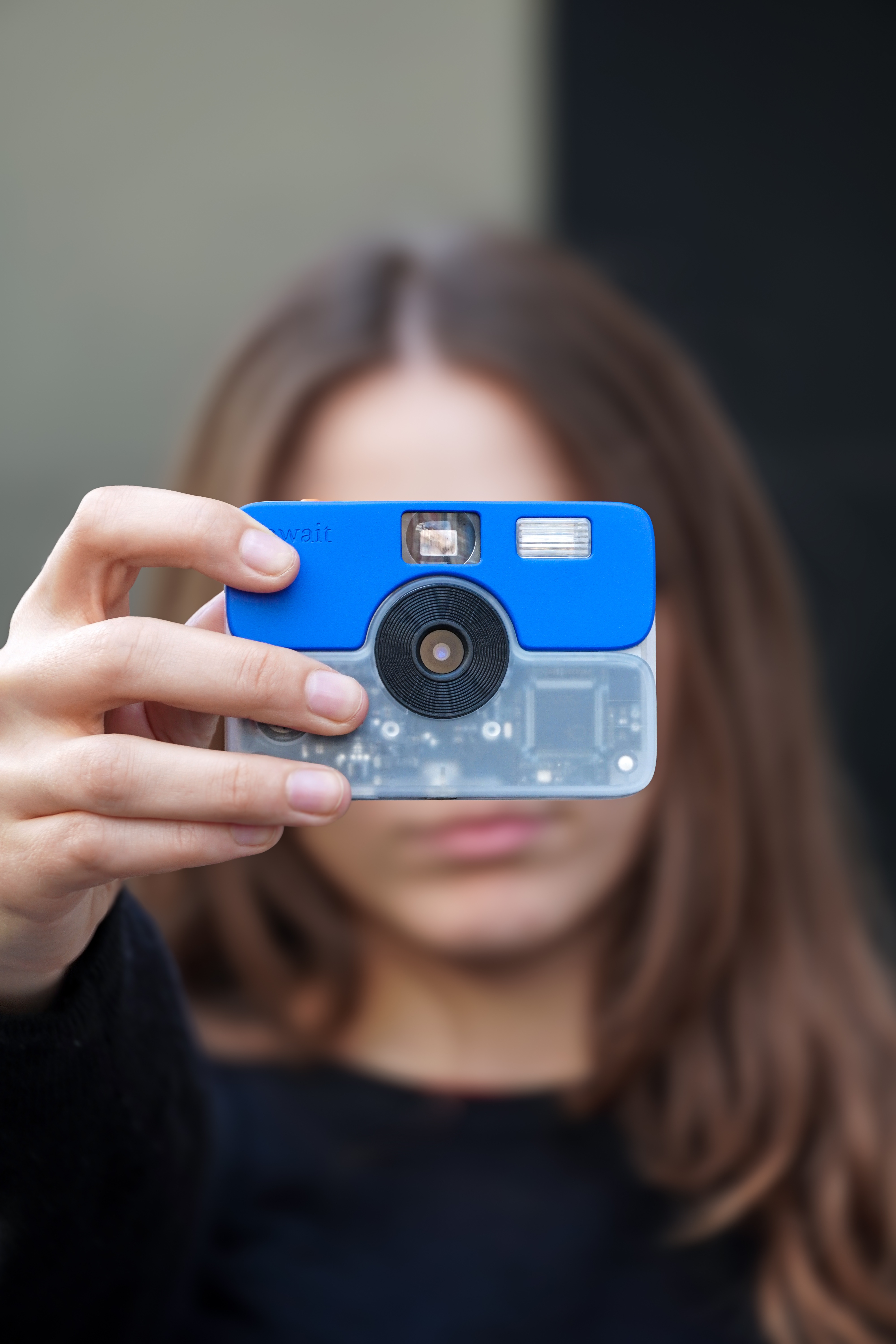 A person raising the Await camera to take a photo