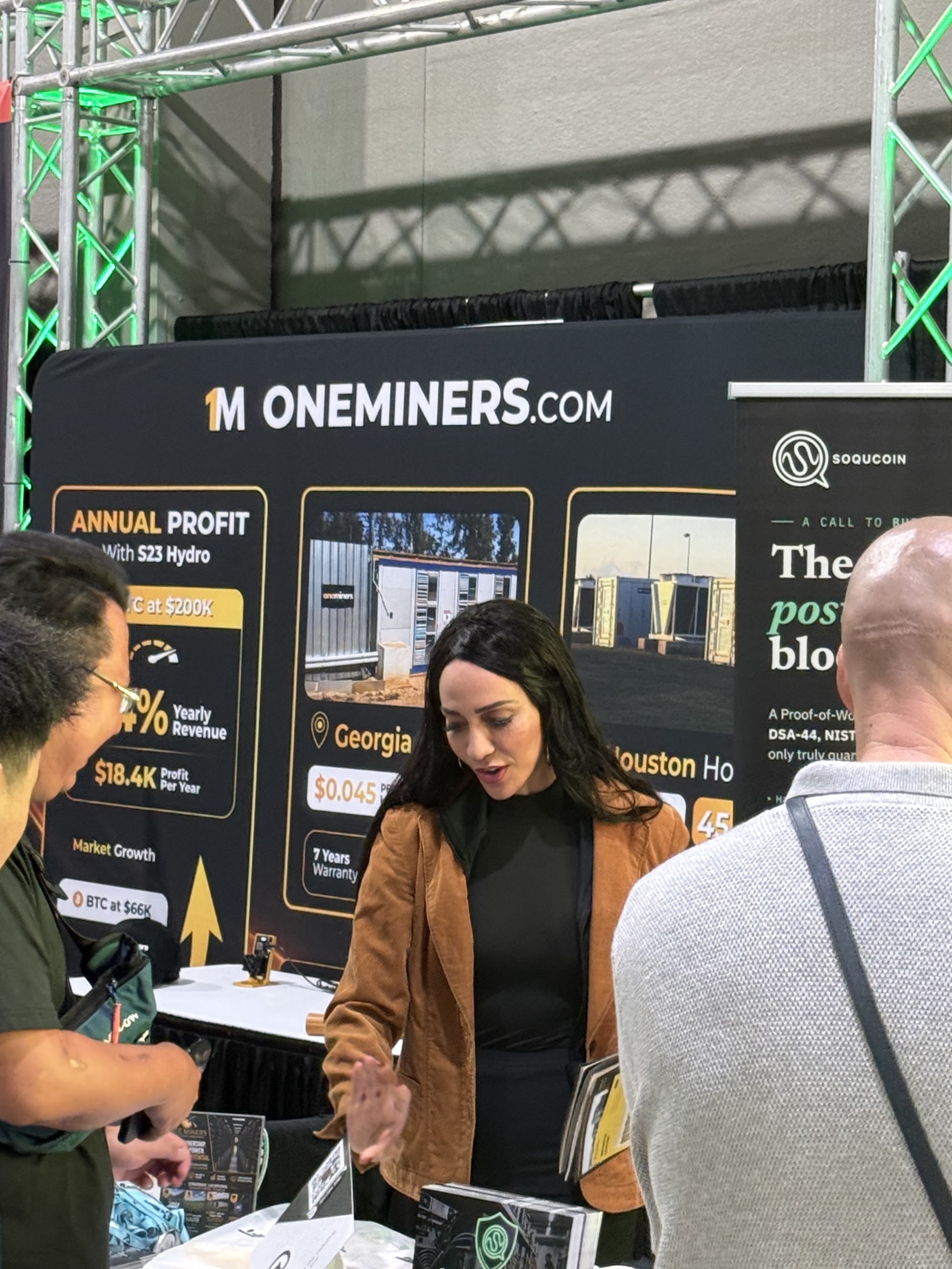 The OneMiners team in conversation with visitors at the booth during Mining Disrupt 2026