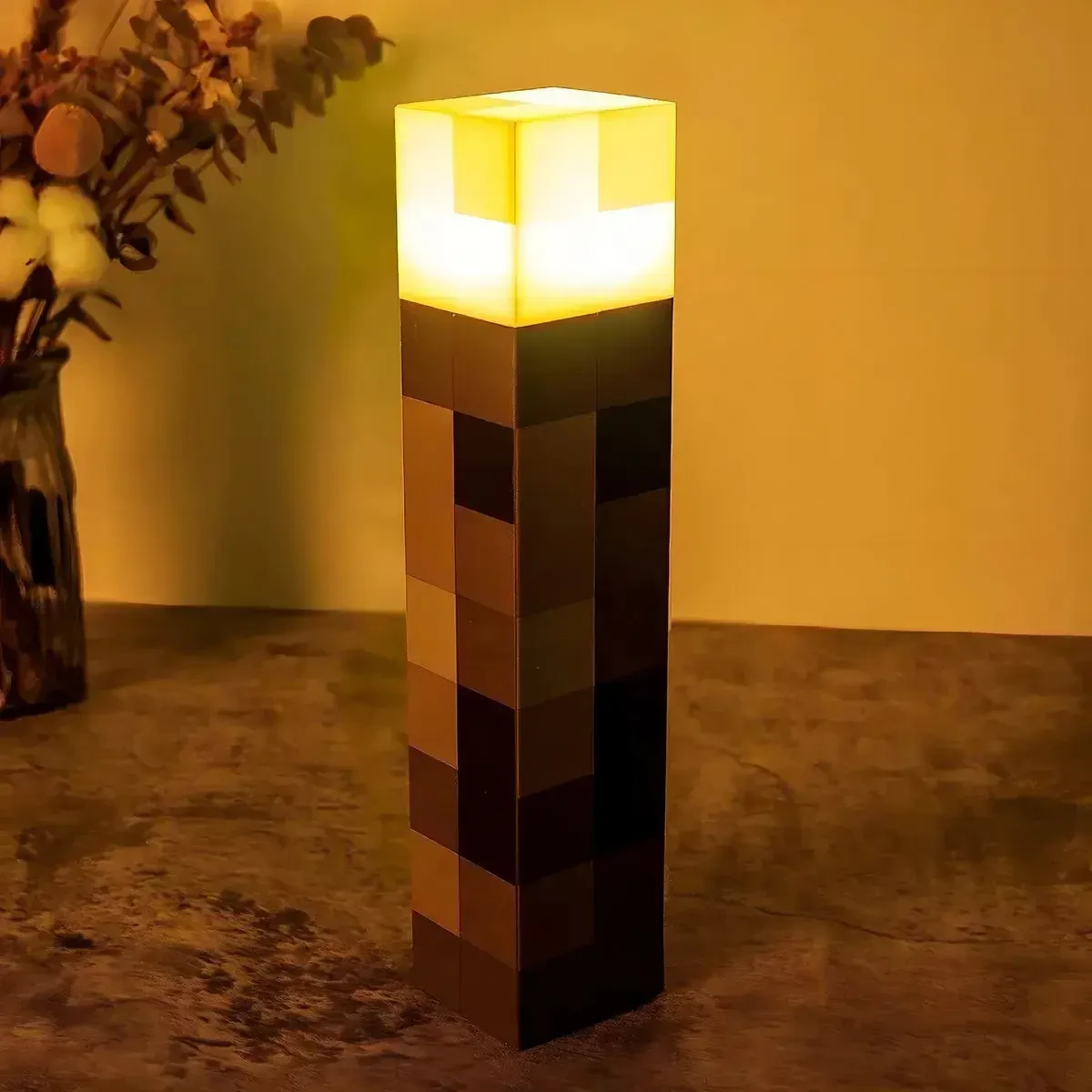 Antorcha Pixel encendida con luz cálida dorada sobre un escritorio
