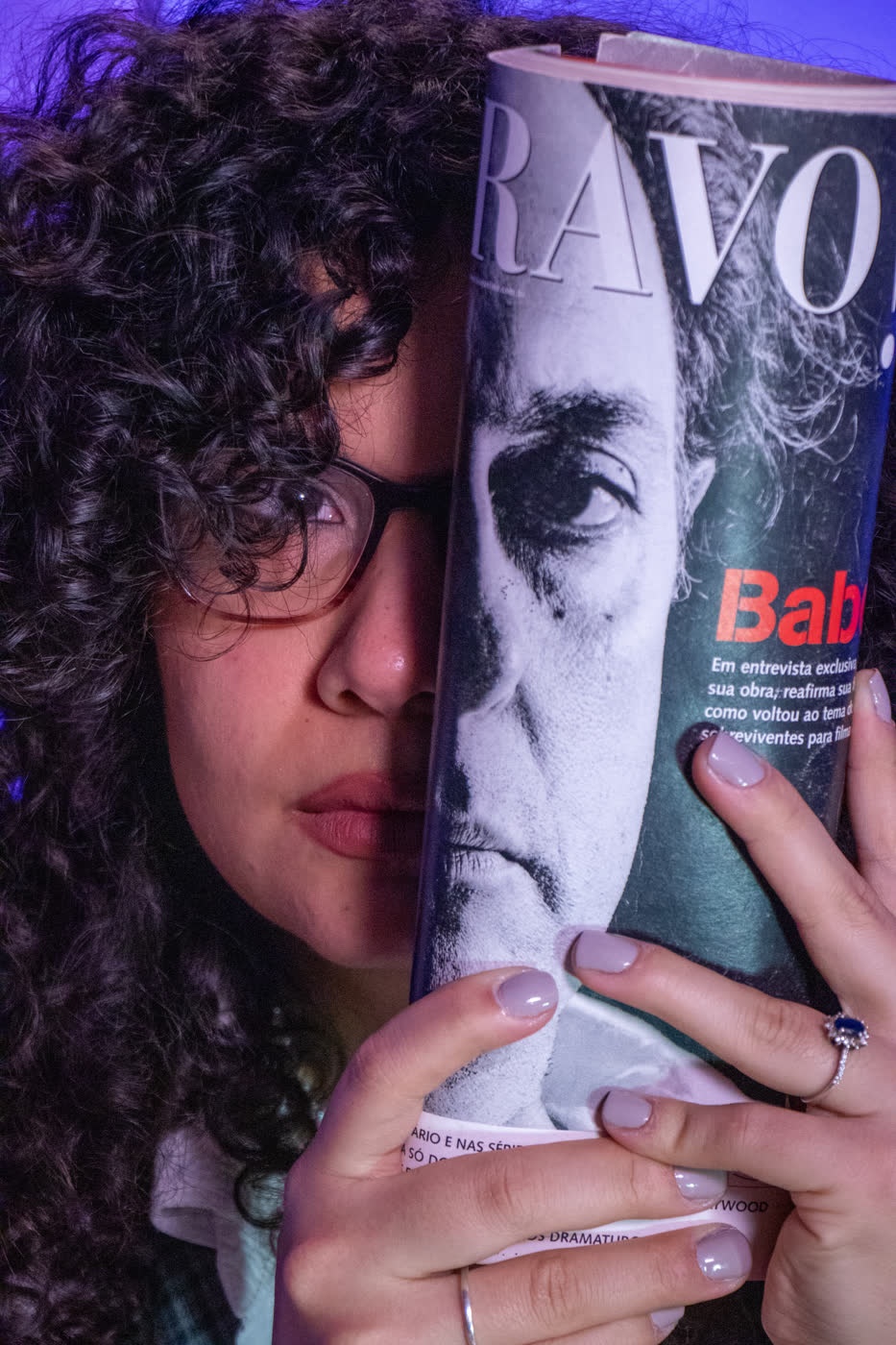 Renata com uma revista de cinema cobrindo metade do rosto