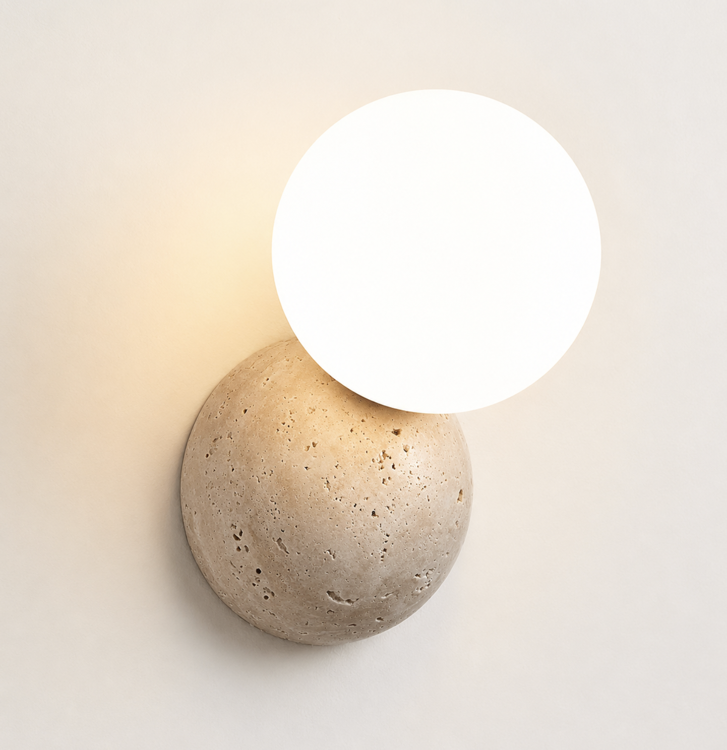 Round travertine disc with frosted glass globe sconce