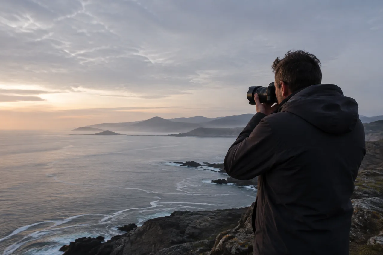 Fotógrafo diante do mar ao pôr do sol