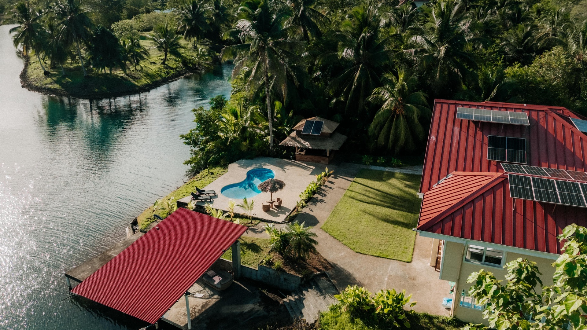 Aerial view of the house, pool, dock and boat against the canal