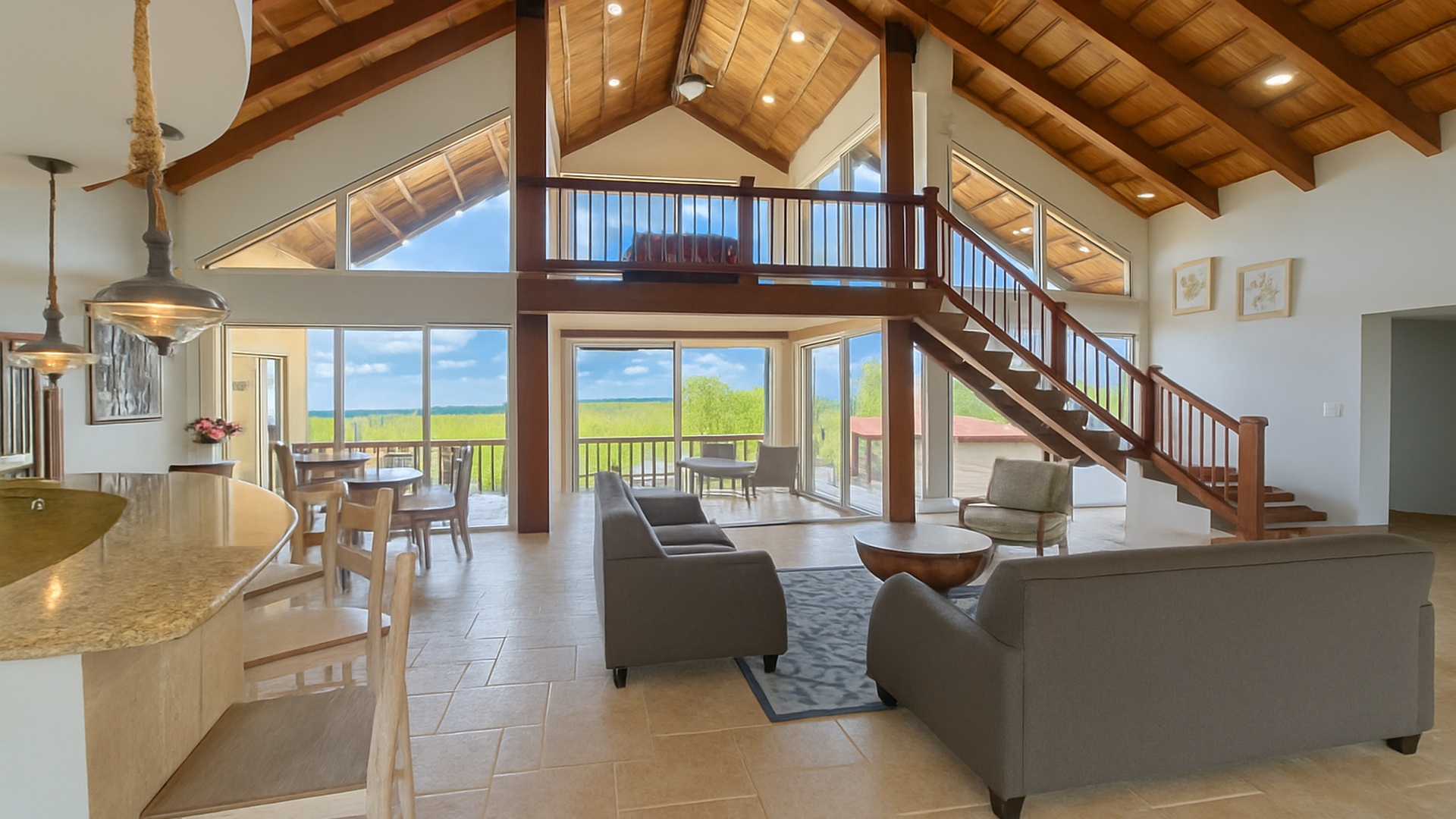The great room in daylight, open to the veranda and the water
