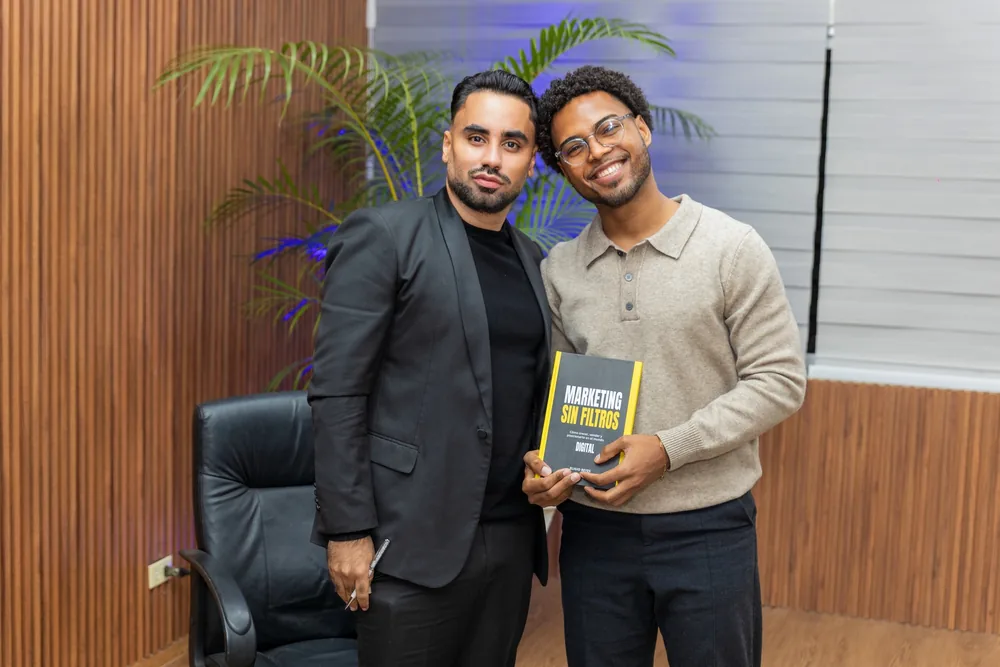 Dos miembros del equipo con el libro en la oficina