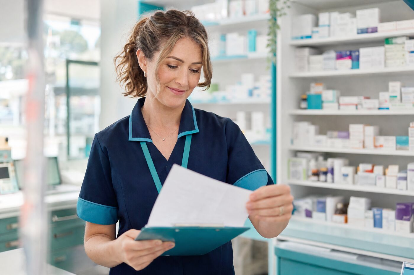 A pharmacist prescriber reviewing a prescription and blood test results in the clinic dispensary