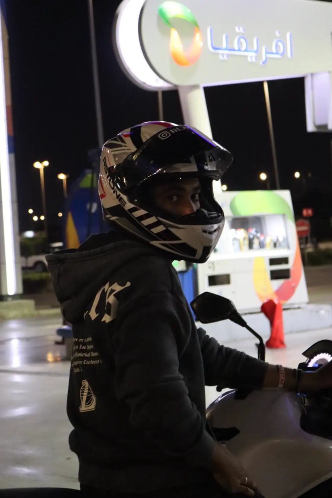 Portrait sur le terrain, casque de moto en main.