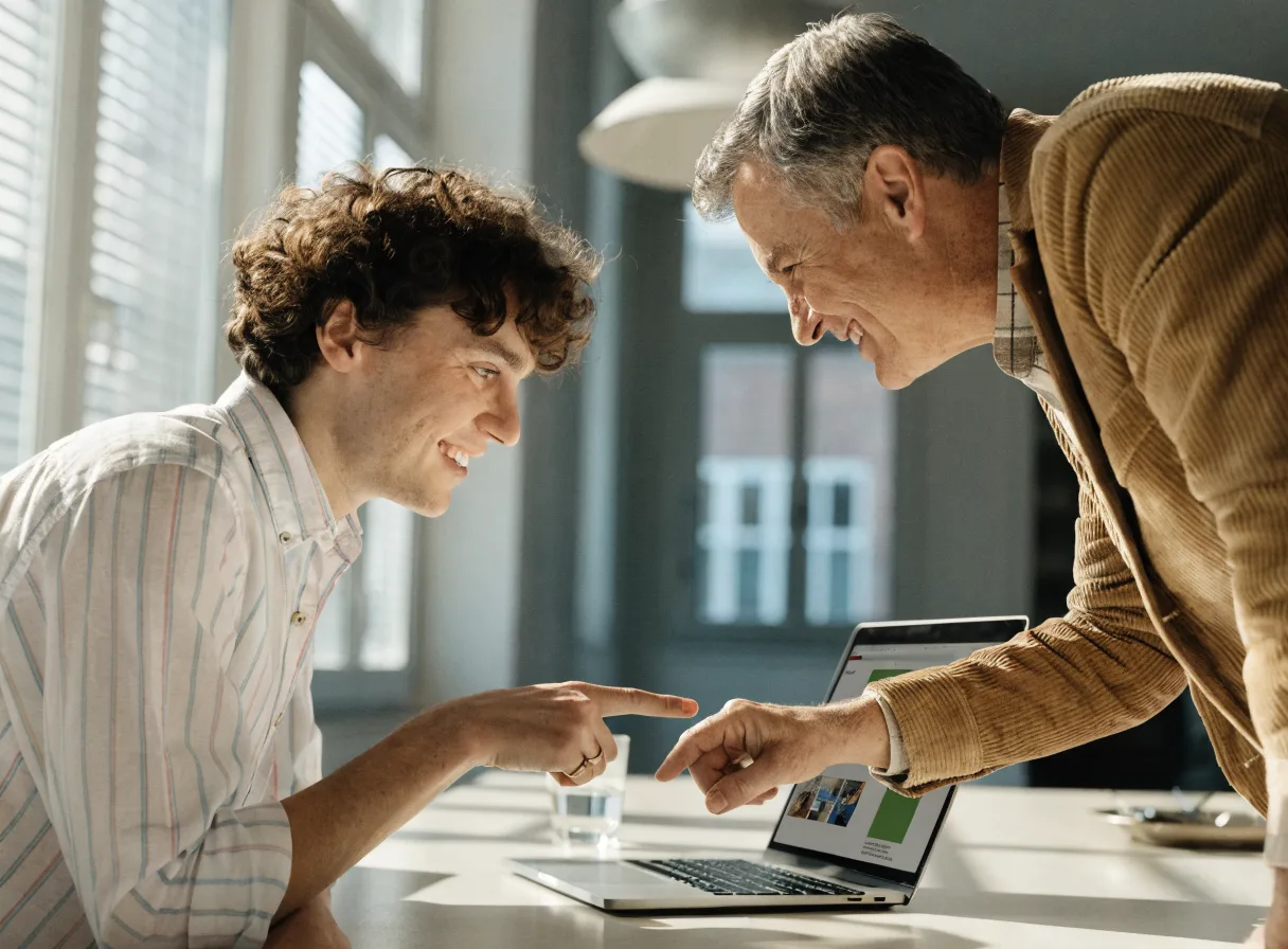 Local business owner and web team reviewing a new site build on a laptop