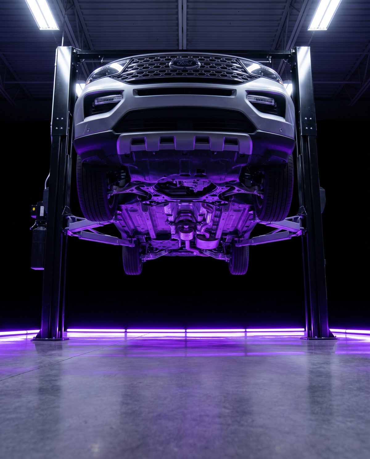 Ford Explorer on a service lift in the Tom’s Ford service bay — inspections included