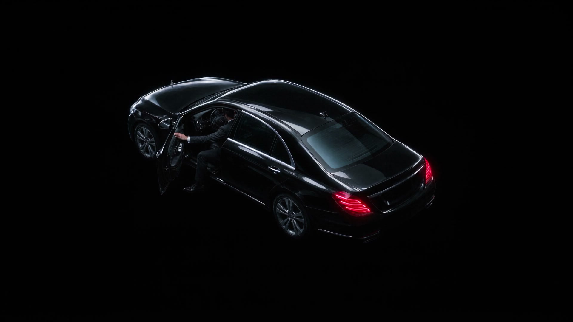 Top-down view of a black Mercedes S-Class at night, the opening frame of the car rental site