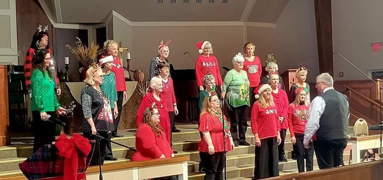 The chorus in red and green at a Christmas show