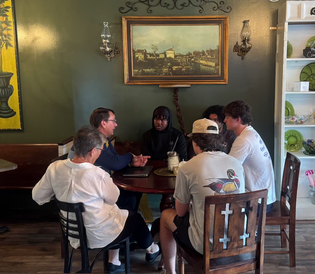 Students and faculty gathered around a table at Vintage Style in Summit, Mississippi
