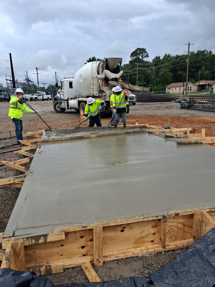 Concrete truck and crew placing a slab