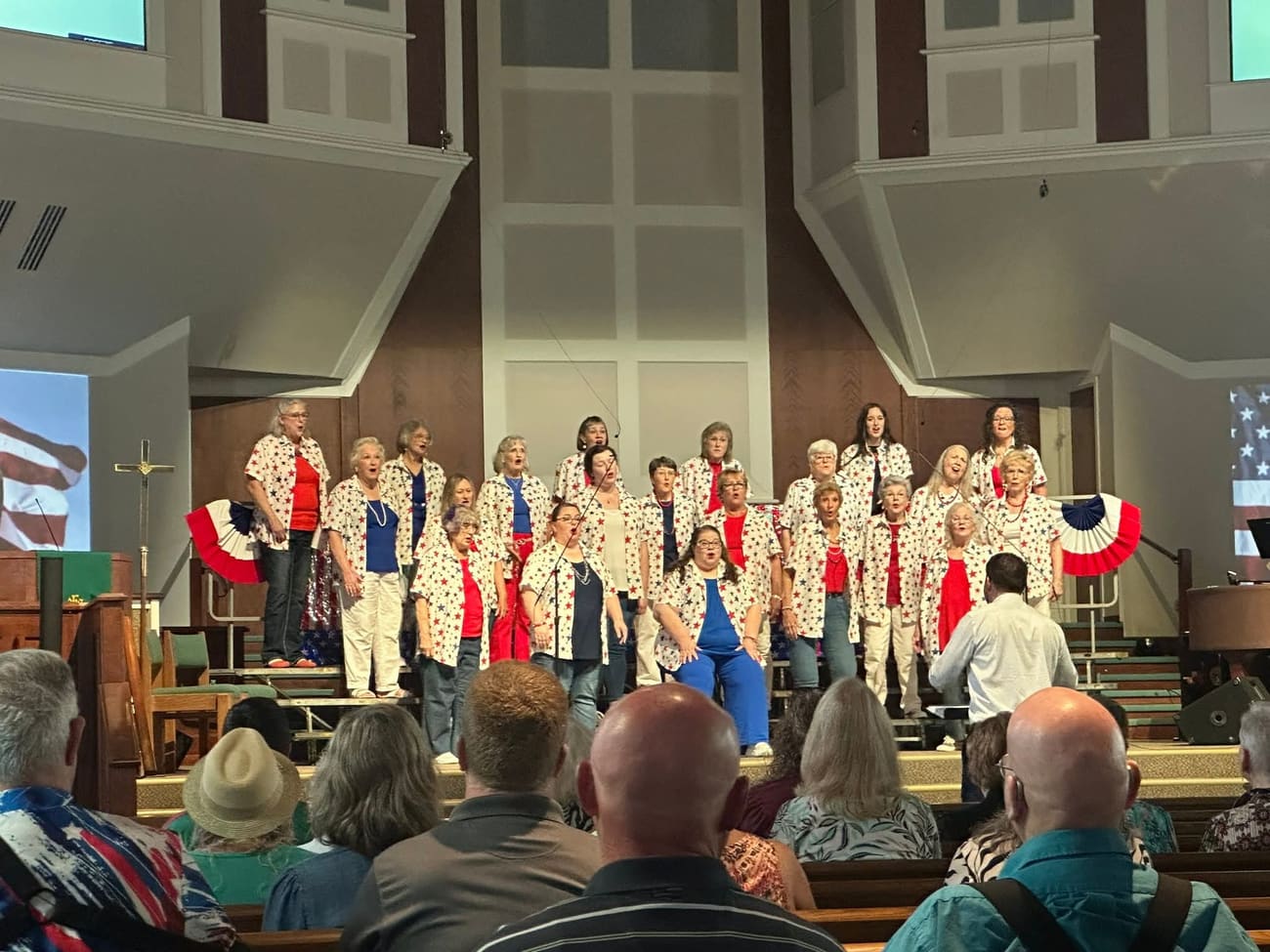 The chorus in star-patterned shirts singing to a full house