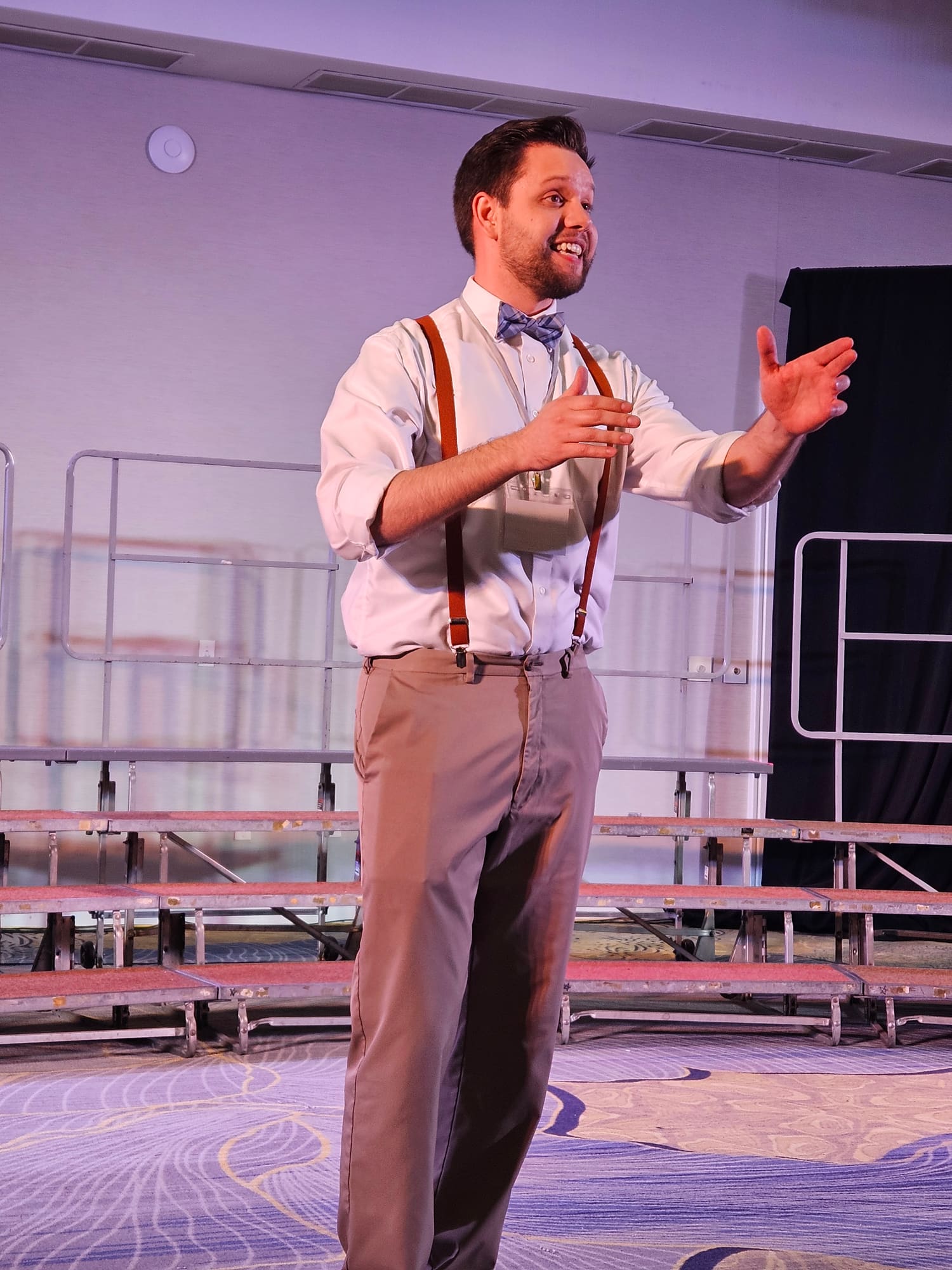 Jacob, the chorus director, conducting with both hands raised