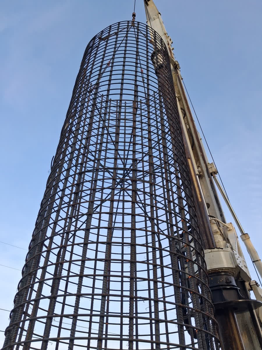 Tall rebar cage being lifted vertically