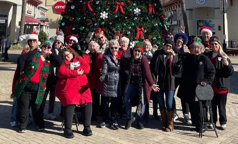 The chorus in holiday sweaters and hats outdoors