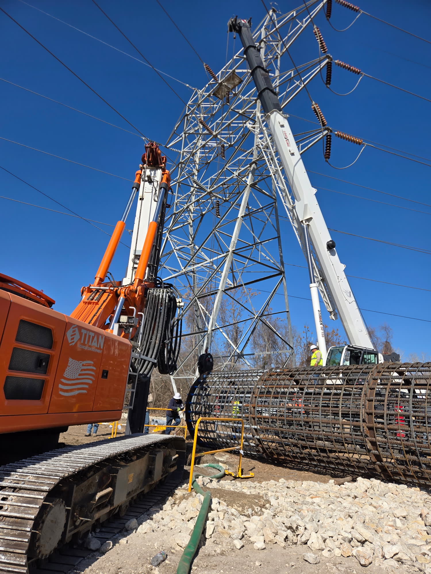 Crane and drill rig working at a transmission tower