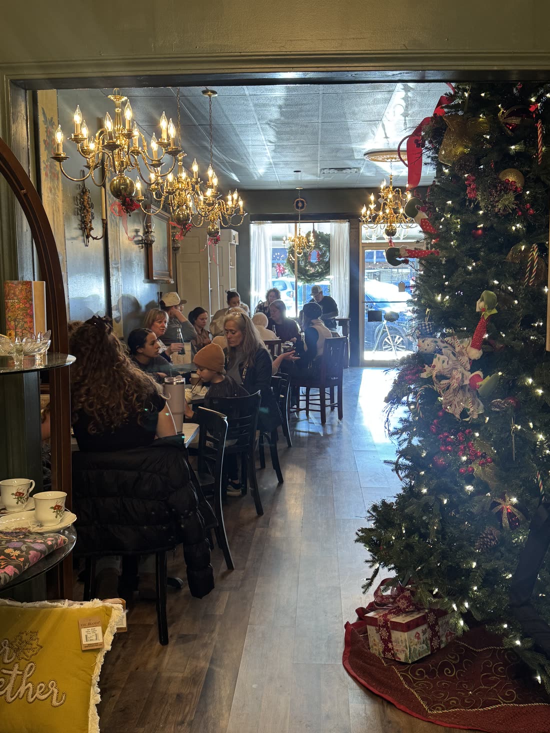 A full room of guests at tables under the brass chandeliers at Vintage Style