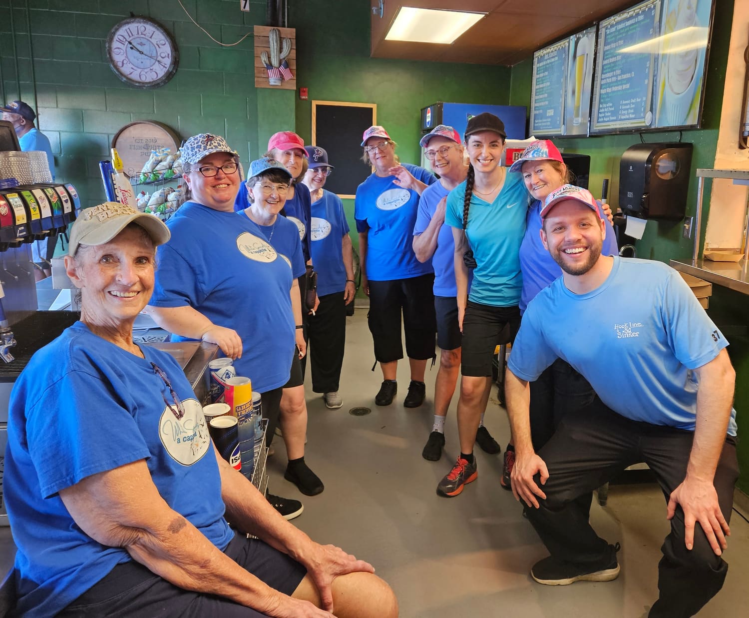 Chorus members in matching blue shirts volunteering together at a Blue Wahoos game