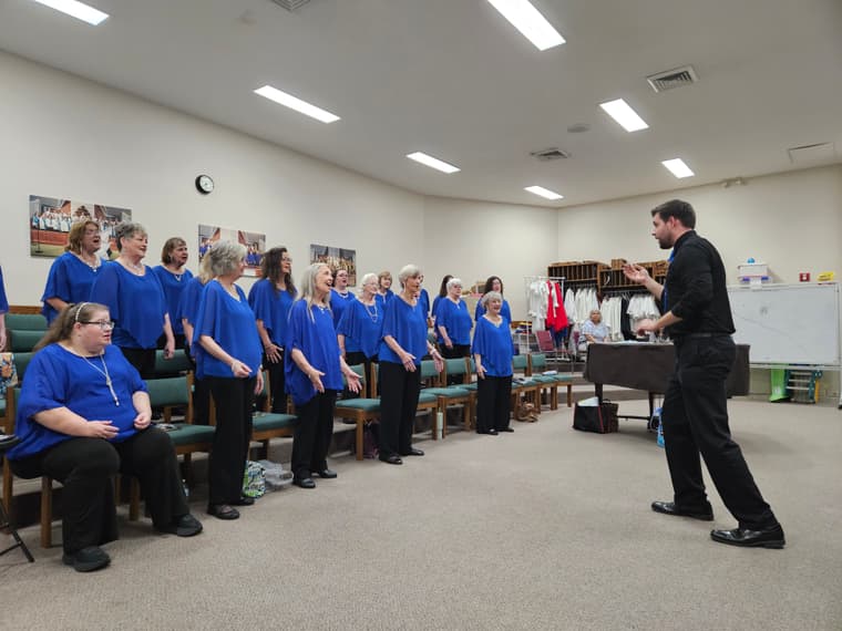 The chorus rehearsing in blue shirts for friends and family